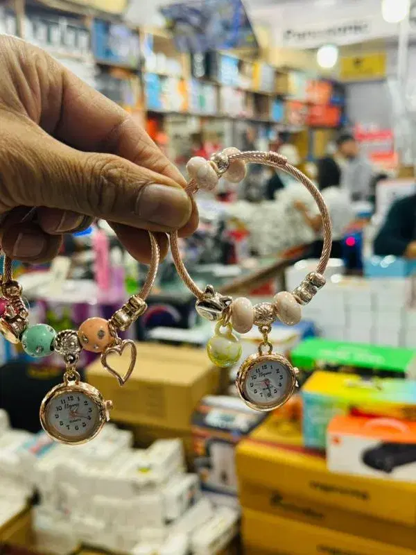 Charm Bracelet Watch With Various Charms Hanging.