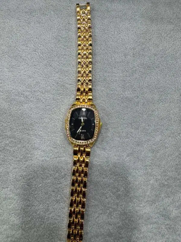 Gold-toned daimond-encrusted "caurel" Quartz ladies' watch with a dark dail and roman numerals