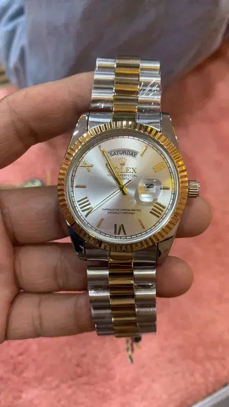 Rolex Oyster Perpetual Day-Date watch with a fluted bezel and silver dial.