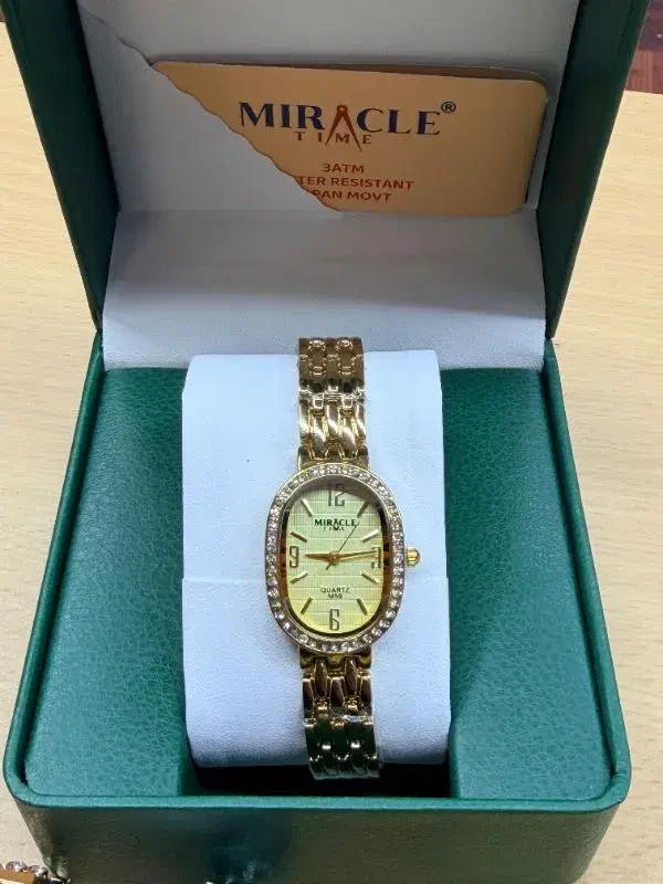 Miracle quartz watch, model M59, features a distinctive oval dial adorned with decorative rhinestones and a complementary metallic bracelet.