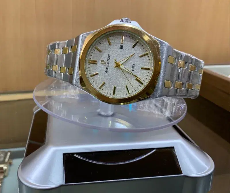 Audemars Piguet wristwatch featuring a silver-toned dial, a gold-toned bezel, and a two-tone metal bracelet.