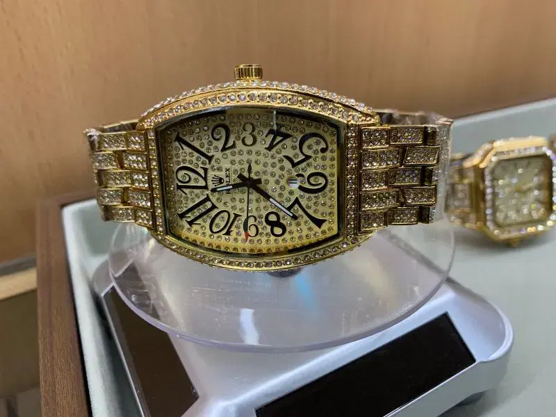 gold-toned rhinestone iced-out wristwatch featuring a tonneau-shaped case