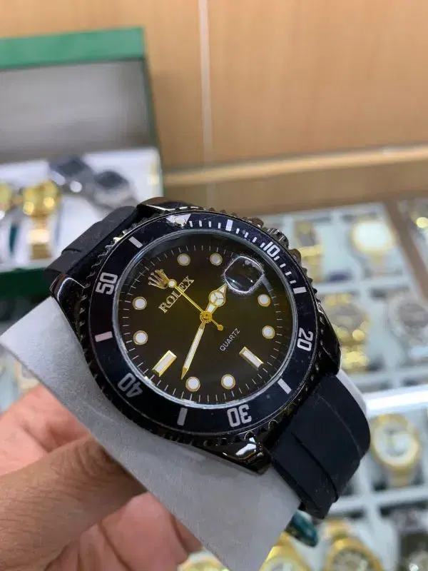 black watch with a rubber strap, resembling a Rolex Submariner style.