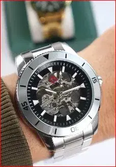 men's automatic watch with a skeleton dial and a silver-tone metal bracelet.