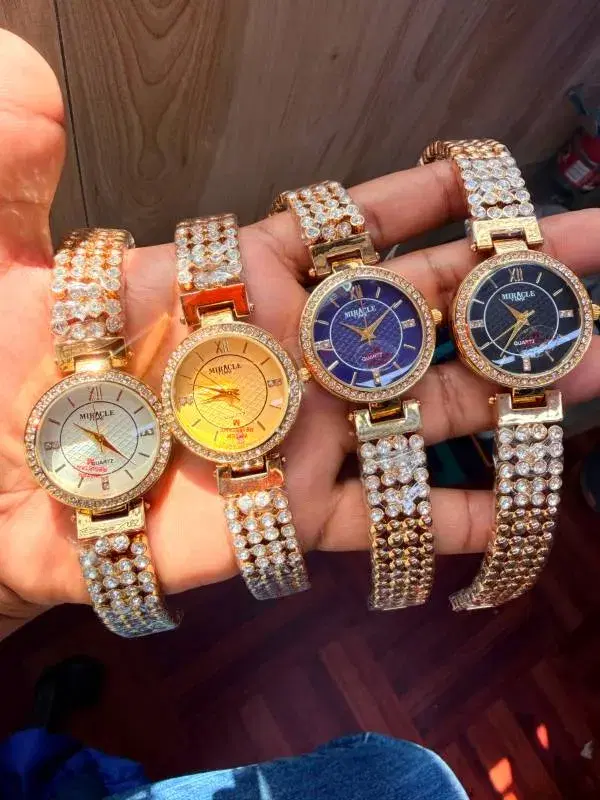gold-toned women's wristwatches featuring rhinestone-encrusted bracelets