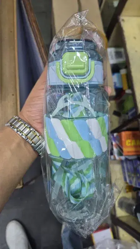 transparent plastic water bottle featuring a blue and green strap